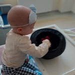 Dziecko w trakcie zabawy z Magikiem wyjmuje królika z kapelusza