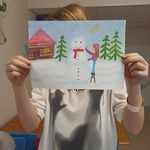 Uczennica pokazuje swoją pracę Bałwan w czerwonym szaliku