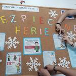 uczniowie wieszają informacje przypominające o bezpieczeństwie podczas ferii zimowych