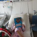 dziewczynka na łóżku z wybraną kartką z misiem