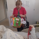 nauczycielka przekazuje kartkę leżącemu dziecku po zabiegu