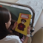 dziewczynka przy łóżku z kartką z misiem na żółtym