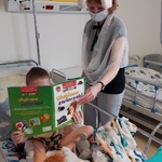 Dziecko ogląda ilustracje i słucha o ulubionych zwierzakach z książki prezentowanej przez nauczycielkę w przebraniu króliczka