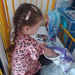 Dziewczynka bierze udział w zabawie losując jajeczka z wielkanocnego woreczka
