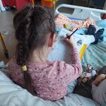 Dziewczynka koloruje wielkanocne jajo