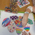 Uczennica malująca pastelami olejnymi kolorowe pisanki