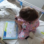 Dziewczynka wykonuje zadanie w karcie edukacyjnej Koloruje