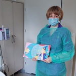 Nauczycielka prowadzi zajęcia czytelniczo-plastyczne w sali chorego dziecka, zachęca do wysłuchania wiersza