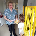 Dziewczynka wybiera pomoce do wykonania laurki prezentowane przez nauczycielkę