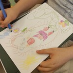 Chłopiec rysujący Wiosnę z kwiatkiem w ręce