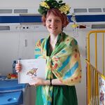 Nauczycielka w przebraniu za Panią Lato trzyma książkę o lecie