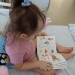 Dziewczynka rozwiązuje zagadki ilustracyjne i uczestniczy w grze słownej