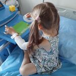 Dziewczynka wykonuje obrazek z płatków owsianych i makaronu