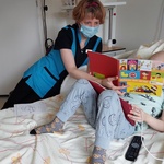 Nauczycielka zachęca dziecko do rozmowy o bezpieczeństwie w trakcie wakacyjnych zabaw w oparciu o broszurę edukacyjną