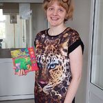 Nauczycielka w przebraniu za węża czyta dziecku książkę o dzikich zwierzętach