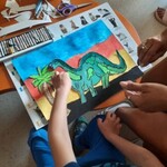 Słoneczna galeria – Urtica dzieciom - chłopiec tworzy pracę z dinozaurem