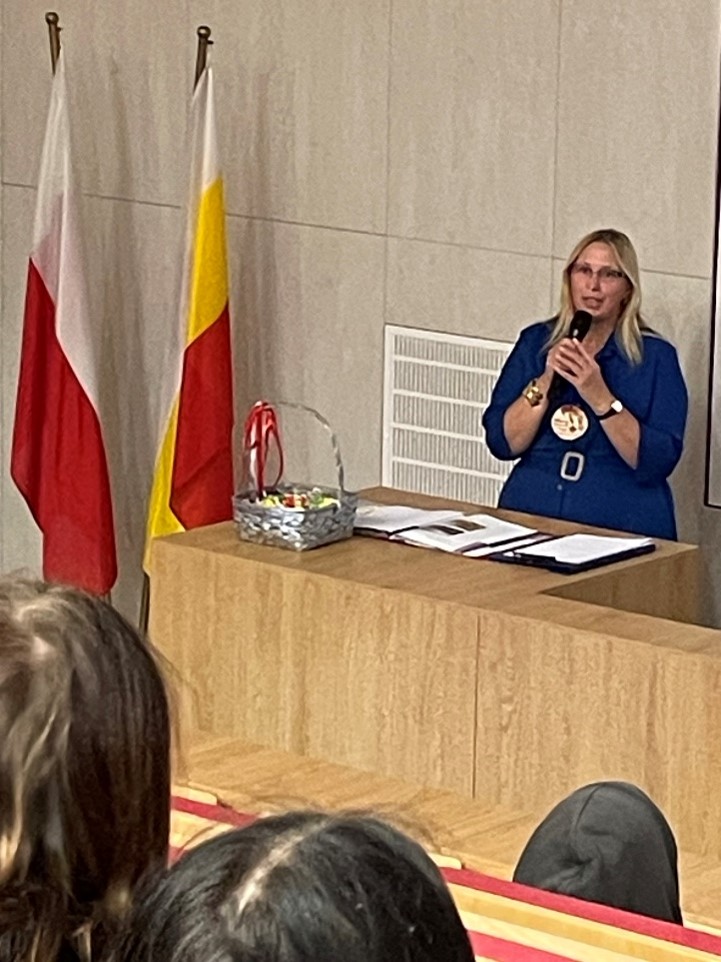 dyrektor szkoły z mikrofonem wita uczestników apelu