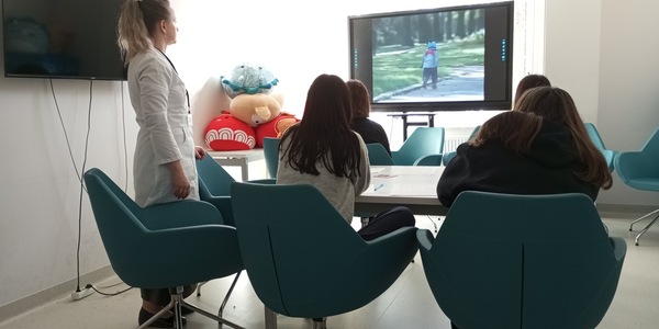 nauczyciel tłumaczy uczniom sceny z filmu edukacyjnego Miało być inaczej