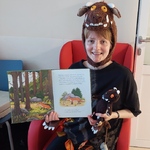 Nauczycielka w przebraniu za stwora z opowieści prezentuje ilustrację w książce o Gruffalo