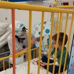 Chłopiec wybiera śnieżynkę z zagadką zawieszoną na śniegowej chmurce trzymanej przez nauczycielkę w przebraniu Olafa