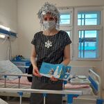Nauczycielka czyta dziecku książkę o radości lepienia bałwanka w aranżacji zimowej