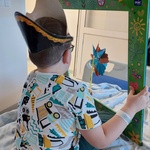Chłopiec w czapce pirata i z wiatraczkiem pozuje do zdjęcia w foto ramce