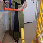 Nauczycielka trzyma bum bum rurki i prowadzi zabawę rytmiczną dla dziecka