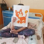 Dziewczynka pokazuje kota wykonanego technika wydzierania