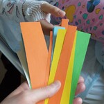 Nauczycielka trzyma paski z cytatami o przyjaźni a dziecko jeden wybrany losuje