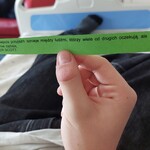 W rękach dziecka pasek z cytatem Najpiękniejsza przyjaźń istnieje między ludźmi, którzy wiele od drugich oczekują, ale nigdy ... nie żądają