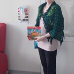Nauczycielka w przebraniu za jeża prezentuje książkę Dzieciaki poznają leśne zwierzaki