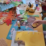 Dzieci wycinają dziurkaczami kwiatki z kolorowego papieru