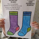 Dziecko prezentuje niebieską i fioletową skarpetkę