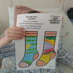 Uczeń pokazuje skarpetki w zielone paski i żółtymi dodatkami