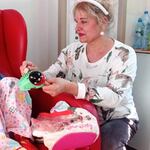 Dziecko uczestniczy w zabawie z instrumentami, nauczycielka jako zajączek uczy grania na drewnianej żabie i grzechotce