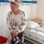 Dziecko uczestniczy w zabawie z instrumentami, nauczycielka jako zajączek uczy grania na drewnianej żabie i grzechotce