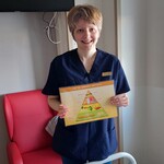 Nauczycielka prezentuje dziecku ilustrację Jak się zdrowo odżywiać