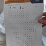 Nauczycielka wręcza dziecku kartę pracy polegająca na kolorowaniu pól według wzoru