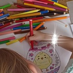 Uczennica kolorująca pisankę z kurczakiem
