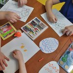 dzieci malują wzory na papierowych pisankach