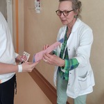 Nauczyciel wręcza dyplom laureatowi konkursu
