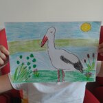 Dziewczynka pokazuje bociana nad rzeką