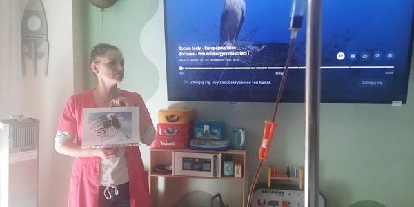 Nauczyciel trzyma zdjęcie bociana