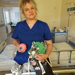 Nauczycielka prowadzi zabawę polegającą na rozwiązywaniu zagadek słowno- dotykowych, wykorzystując przedmioty kojarzące się z porami roku