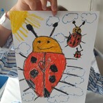 Dziecko pokazuje pracę z biedronkami w czarne kropki