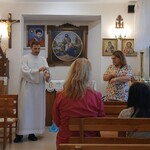 Ksiądz kapelan i pani katechetka ucza piosenki przed nabożeństwem