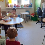 Świetlica oddziału Neurologii w UDSK wypełniona widzami i stolik, na którym stoi zamknięta jeszcze skrzynka butai.