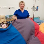 Nauczycielka w trakcie prowadzenia zabawy z chustą animacyjną dla dzieci