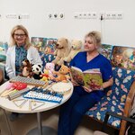 Nauczycielki oddziałów przedszkolnych przy stoliku, wokół misie, książki i instrumenty