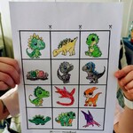 Dziecko pokazuje pokolorowane dinozaury do memory.jpg
